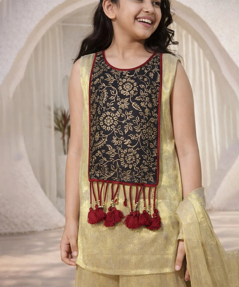 Young girl wearing a traditional outfit with a black and gold top and yellow dupatta.