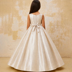 Woman wearing a white dress with a bow detail on a textured beige background