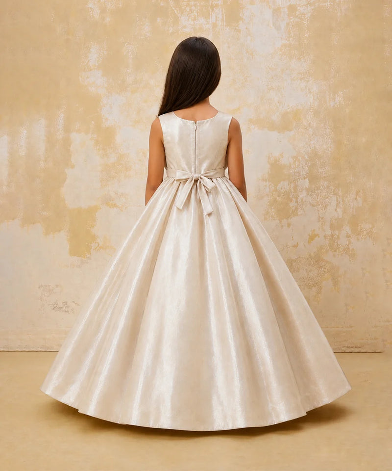 Woman wearing a white dress with a bow detail on a textured beige background