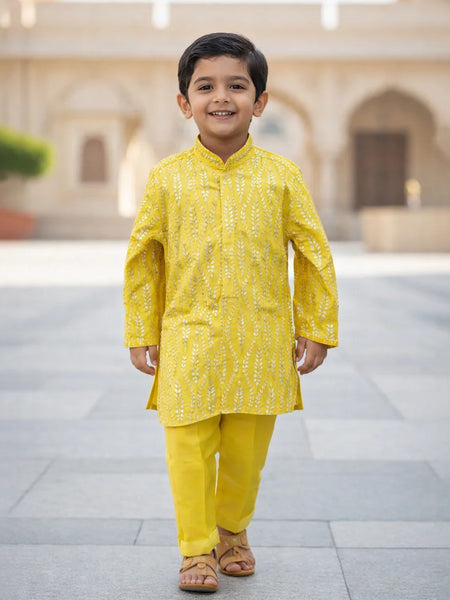 Child wearing a yellow traditional outfit standing in an outdoor setting