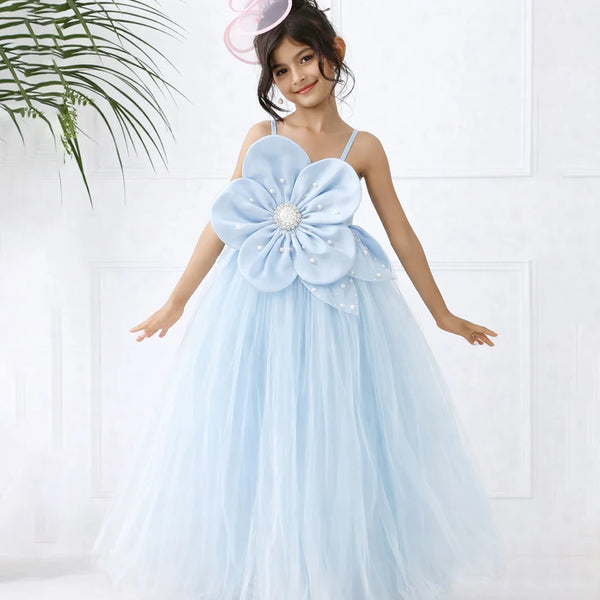 Young girl in a light blue floral dress with a large flower on a white background