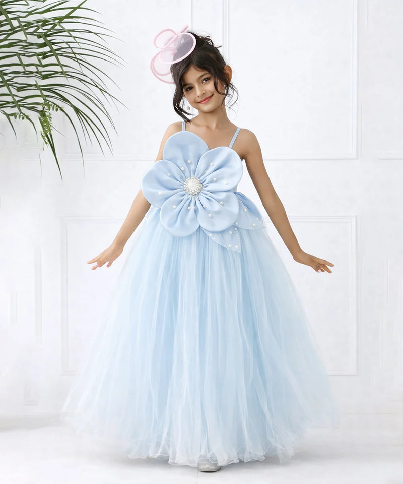 Young girl in a light blue floral dress with a large flower on a white background