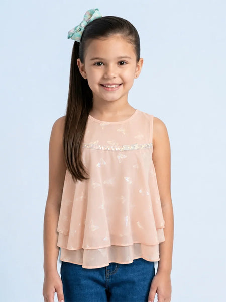 Young girl wearing a light pink top with a subtle pattern on a light blue background