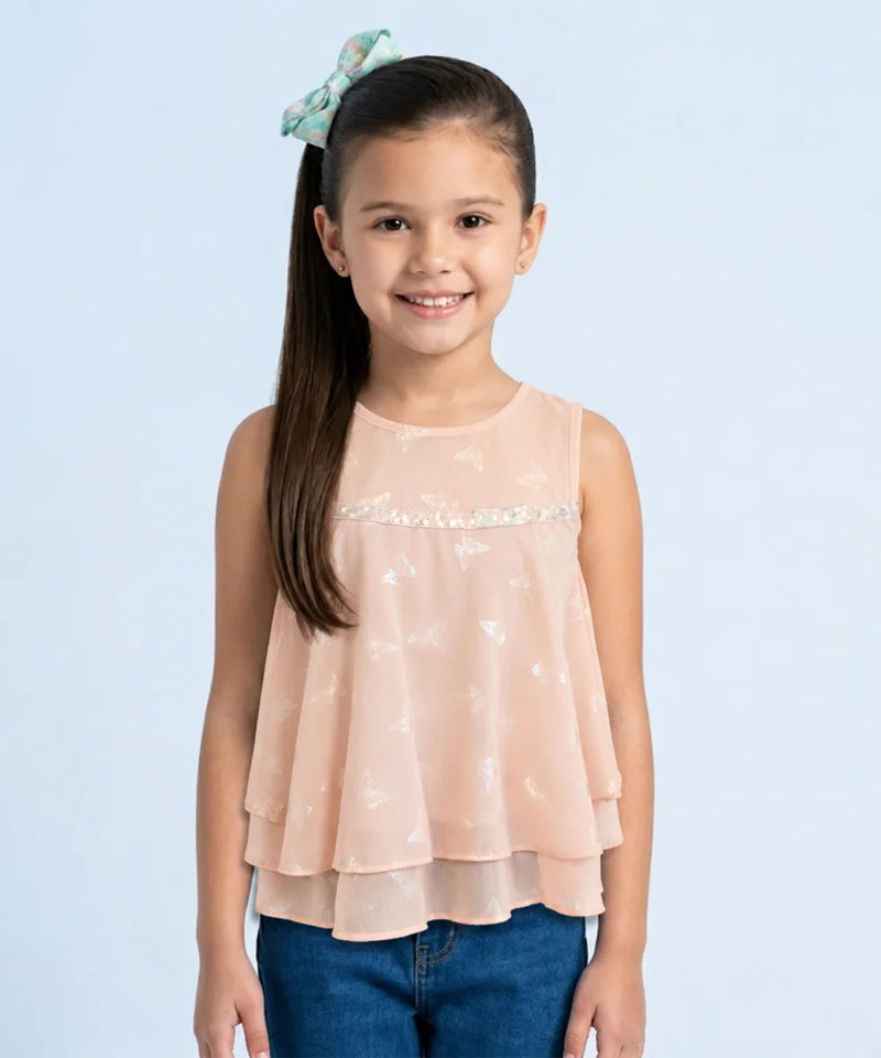 Young girl wearing a light pink top with a subtle pattern on a light blue background