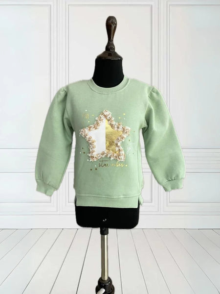 It is a green Colored sweatshirt for girls that has a star print on it and is enhanced with some leafy detailing. 