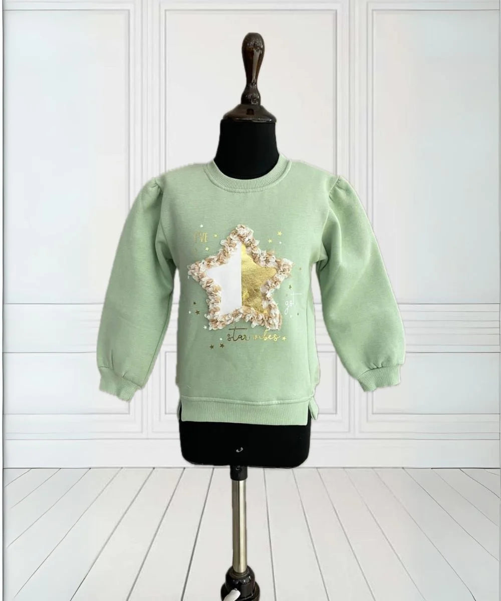 It is a green Colored sweatshirt for girls that has a star print on it and is enhanced with some leafy detailing. 