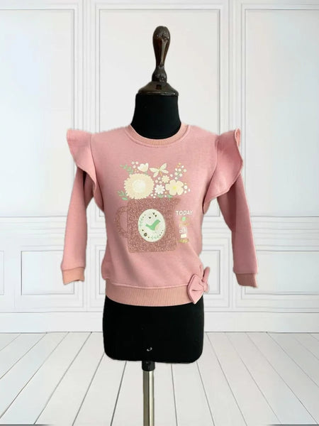 It's an onion pink Colored sweatshirt for girls that comes with a small ruffle detailing on sleeves. It features a beautiful floral print, embossed mug look and 