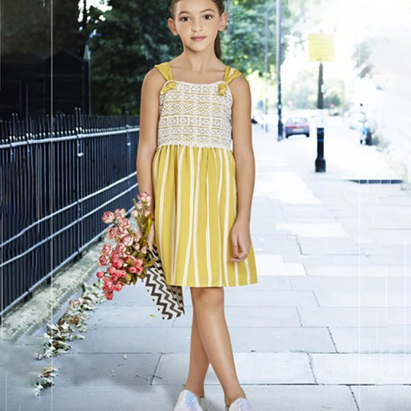  It is a vertical striped Yellow party dress for kid girl. Devils n Angels is a perfect place for online shopping for kids wear in India. It features off-white coloured lace detailing and smocking done at the back part of the dress.