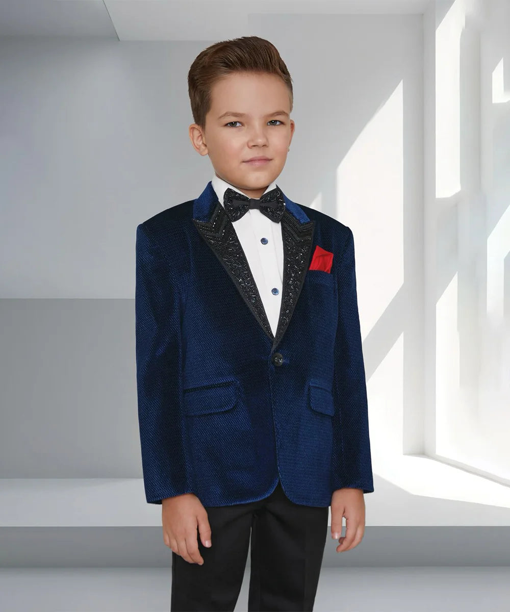 This navy suit consists of a self-textured coat, a white shirt and matching black pants. It features cut Dana work on the collar, a matching bow and a red-coloured pocket square.