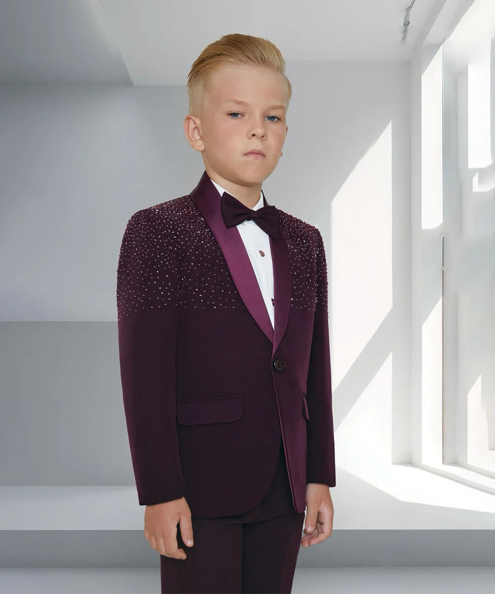 This Wine colored coat suit for boys consists of a coat, matching pants, and a white Colored shirt. It features a matching bow and work detailing on the coat.