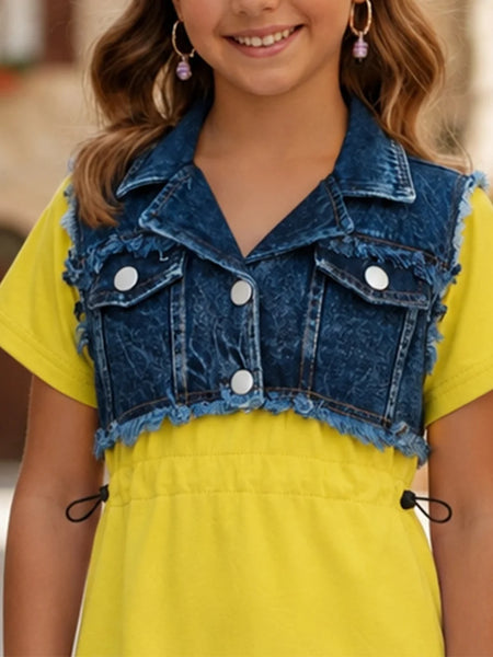 A young girl wearing a bright yellow short-sleeve dress with a blue denim vest overlay featuring frayed edges and white snap buttons.
