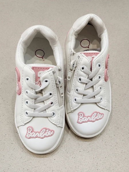 White sneakers with pink accents and 'Barbie' branding on a beige background