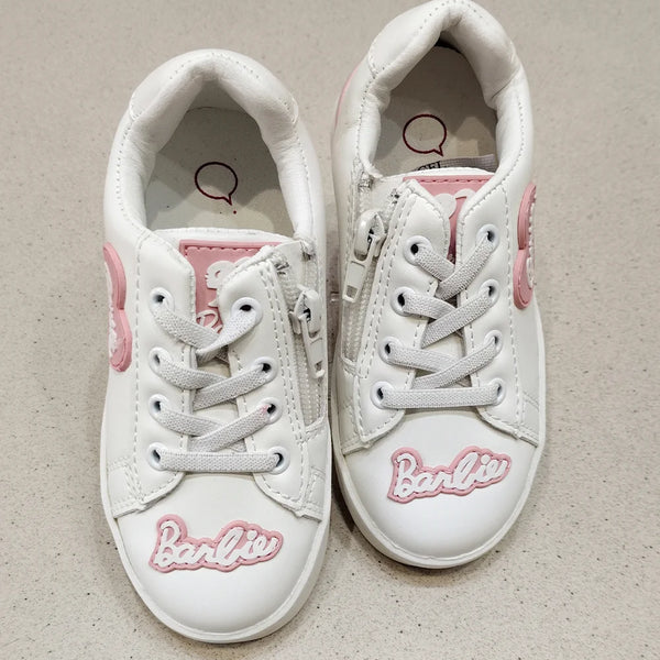 White sneakers with pink accents and 'Barbie' branding on a beige background