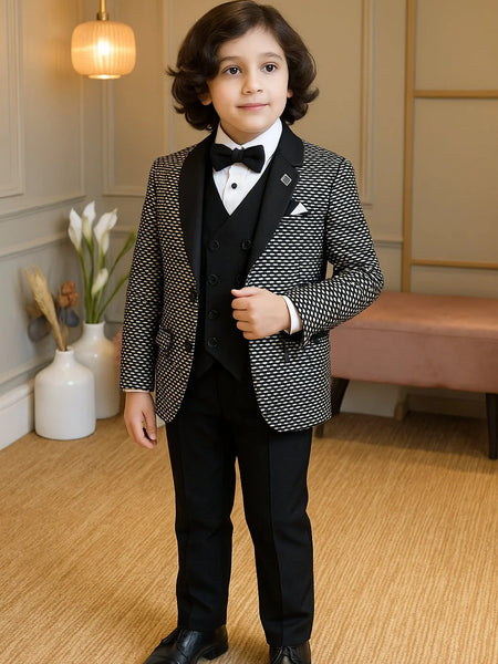 Young boy in a formal suit standing in a room with decorative elements.