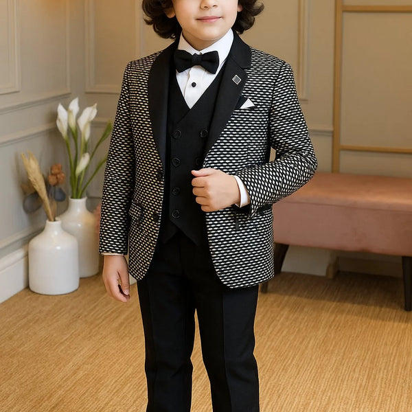 Young boy in a formal suit standing in a room with decorative elements.