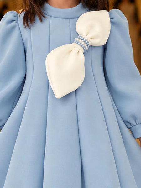 Close-up of girls' sky blue frock with pearl bow
