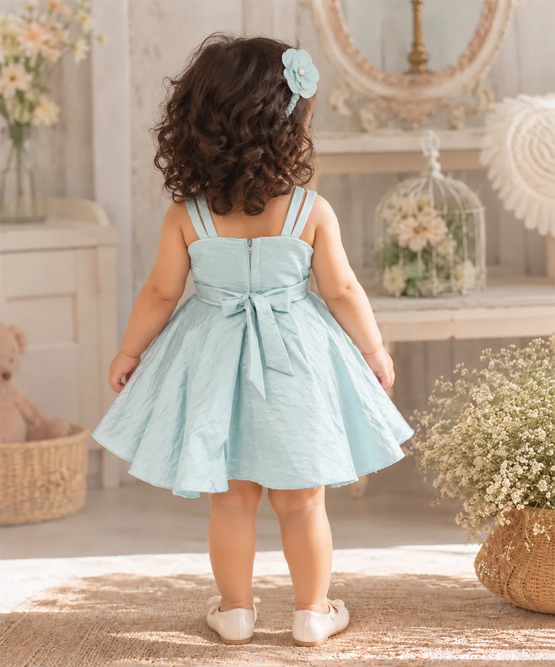 Back view of a pastel blue baby girl party frock with a sleeveless design and a flowing skirt