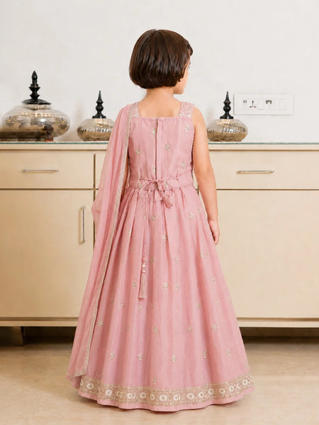 Child wearing a pink traditional dress with a white background