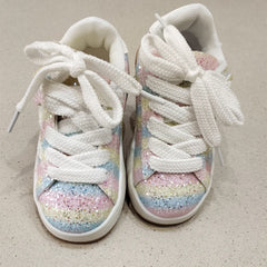 White sneakers with pastel glitter sole on a beige background