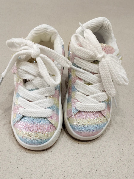 White sneakers with pastel glitter sole on a beige background