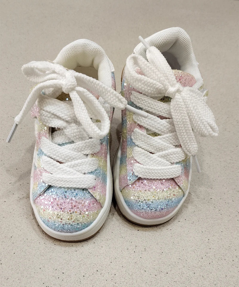 White sneakers with pastel glitter sole on a beige background