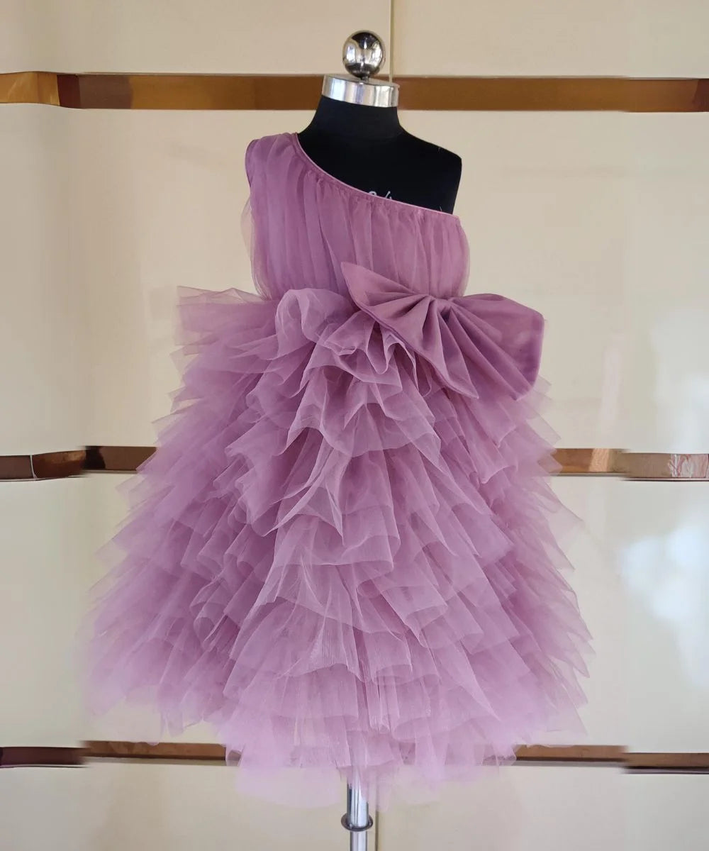 It’s a pink Colored ruffle dress, a perfect children birthday dress as well as girls wedding outfit. It features a beautiful pleated yoke and a big bow detailing that uplifts the entire look.