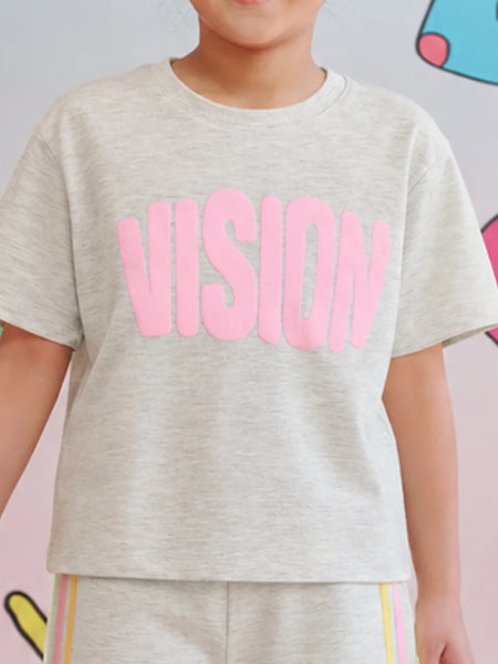 A child wearing a light heather gray short-sleeve t-shirt with the word 'VISION' printed across the chest in large pink letters, paired with matching heather gray pants with thin colored stripes.