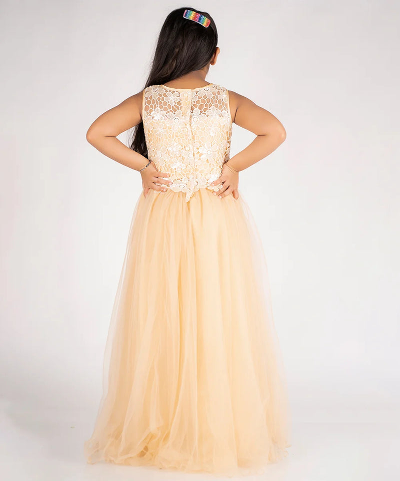 Woman wearing a long, light-colored dress with a lace top on a plain background