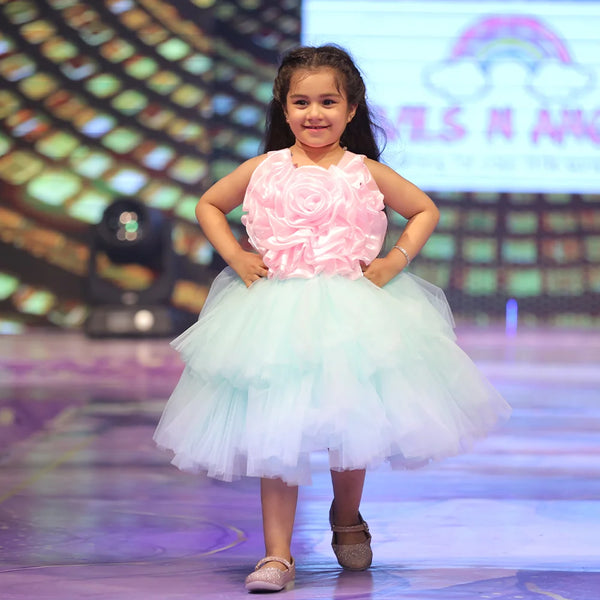 Young girl in a pink and white dress on a stage with colorful background