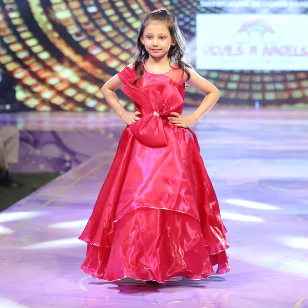 Young girl in a red birthday gown on a stage with a colorful background