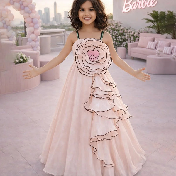 Young girl in a decorated dress with a heart design, standing in a Barbie-themed room.