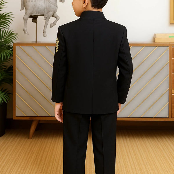 Child wearing a black suit standing in a room with a decorative horse sculpture in the background.