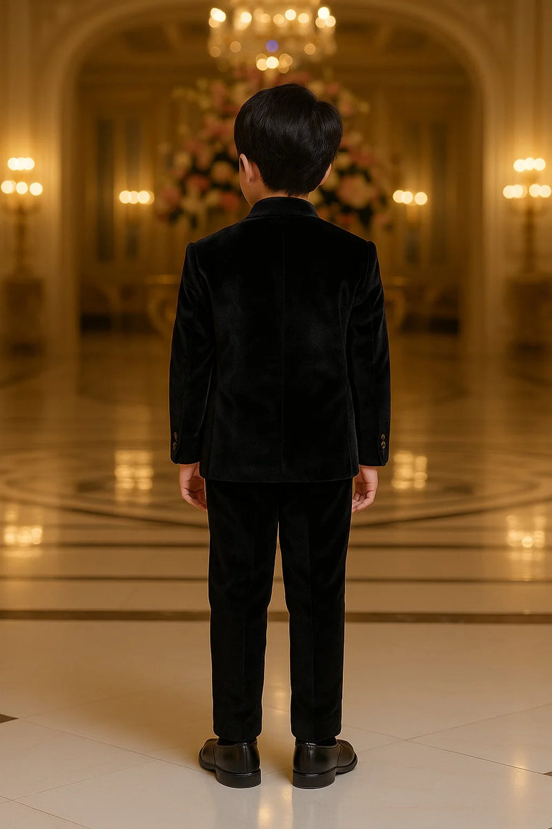 Person wearing a black outfit standing in an elegant indoor setting with chandeliers.