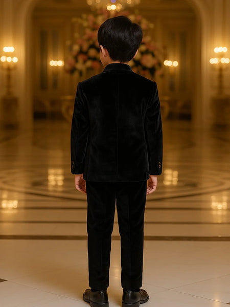 Person wearing a black outfit standing in an elegant indoor setting with chandeliers.