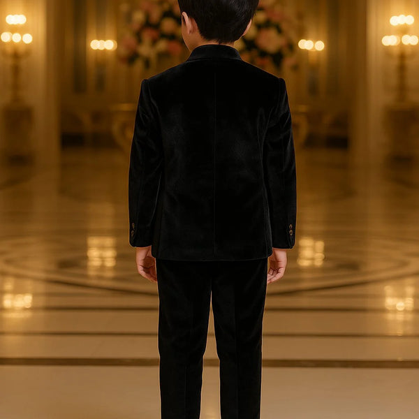 Person wearing a black outfit standing in an elegant indoor setting with chandeliers.