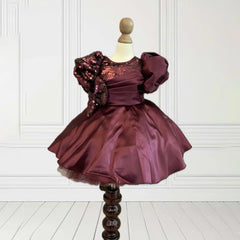This wine coloured beautiful kids frock with a back zip closure has sequin and pleated detailing on its yoke that adds grace to the look. It features cute bow detailing on the waist curated from sequin fabric. Moreover, it comes with a fabric belt to be tied at the back.