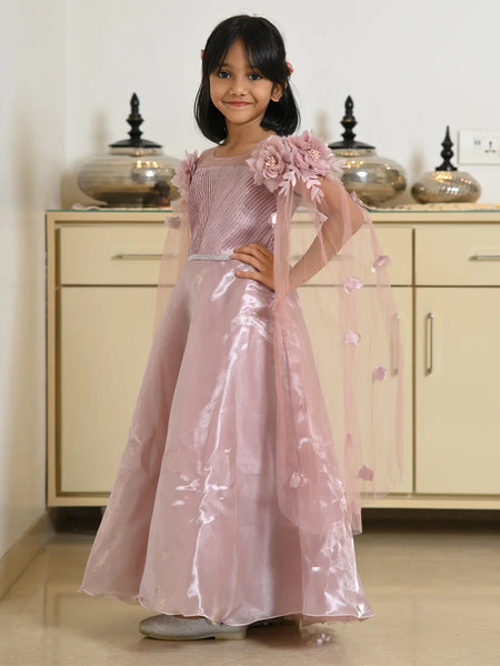 Young girl in a pink floral dress standing in a room with beige cabinets.