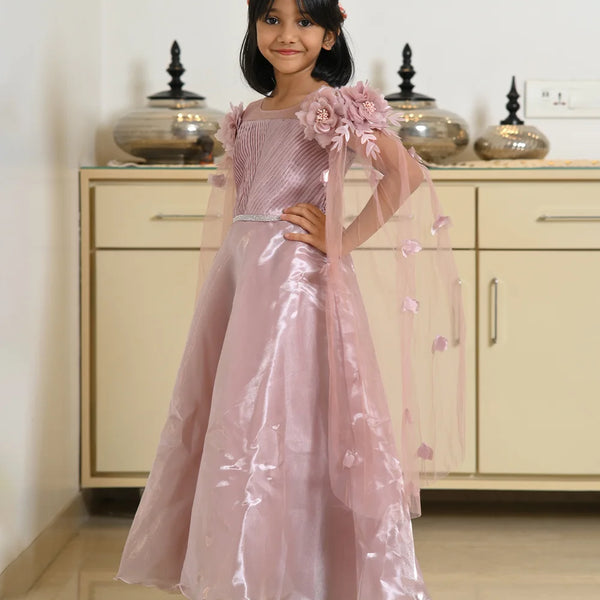 Young girl in a pink floral dress standing in a room with beige cabinets.
