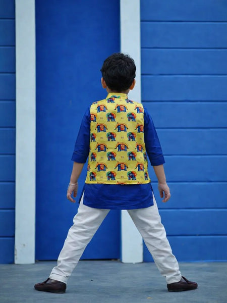 Child wearing a colorful vest with elephant patterns against a blue wall.