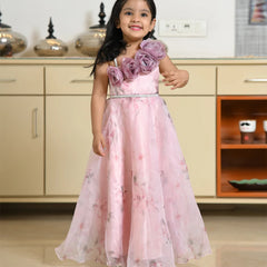Young girl in a pink floral dress standing in a room with cabinets.