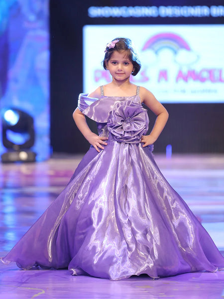 Young girl in a purple dress on a stage with a colorful background