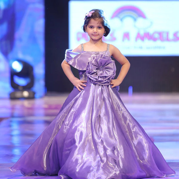 Young girl in a purple dress on a stage with a colorful background