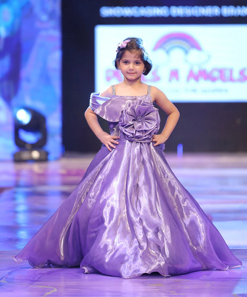 Young girl in a purple dress on a stage with a colorful background