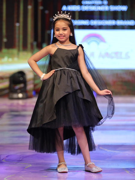 Young girl in a black dress with a tiara on a stage