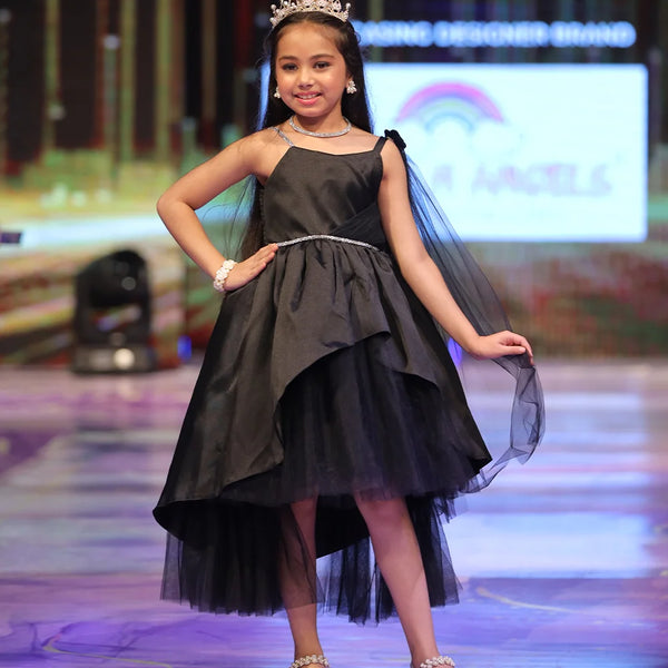 Young girl in a black dress with a tiara on a stage