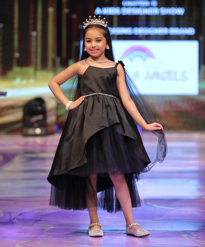 Young girl in a black dress with a tiara on a stage