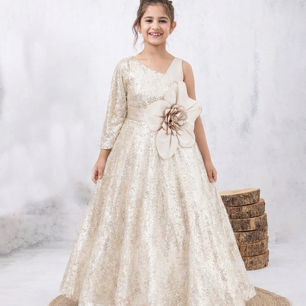 Young girl in a white floral dress standing on a textured surface with a neutral background