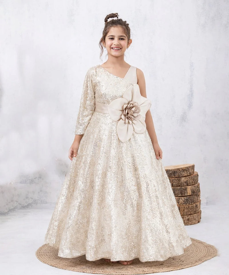 Young girl in a white floral dress standing on a textured surface with a neutral background