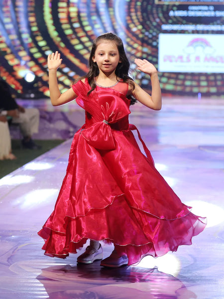 Young girl in a red gown on a stage with colorful background