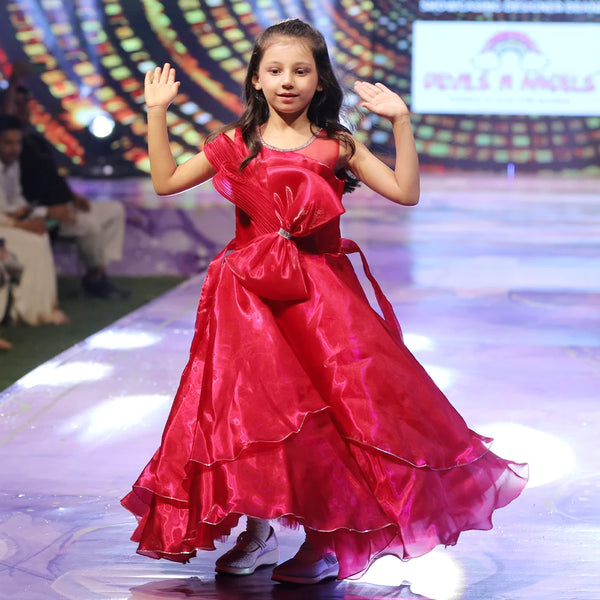Young girl in a red gown on a stage with colorful background